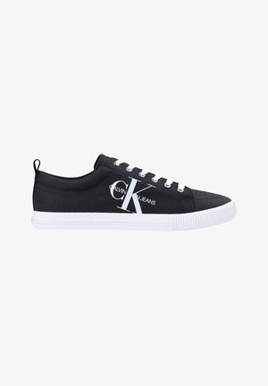 Czarny niski tenisówka z płótna z białymi sznurowadłami, białą gumową podeszwą i dużym logo Calvin Klein Jeans po boku.