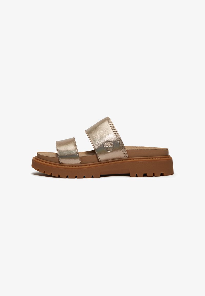 Metalliset kultaiset liukusandaalit, joissa on kaksi remmiä; teksturoitu sisäpohja, kuminen ulkopohja urilla ja logoyksityiskohta yhdessä remmissä.