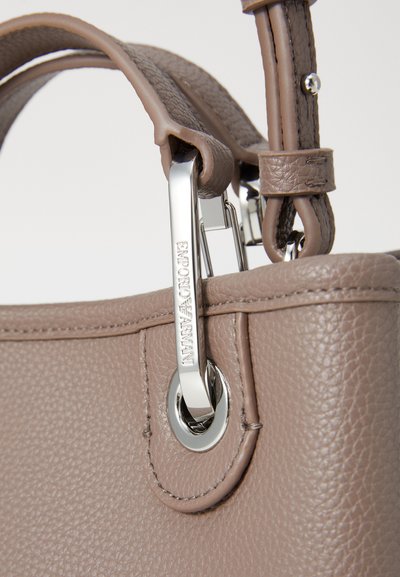 Brown textured leather handbag with a silver hardware accent and a detachable clip. Features a smooth, round opening for attachment.