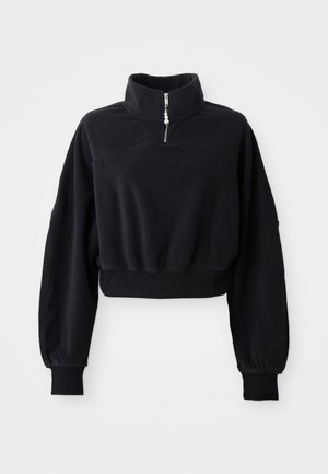 Sweatshirt preto cropped com gola alta, fecho de meia-zíper e mangas longas ligeiramente bufantes. Feito de um tecido suave e texturizado.