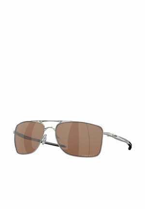 Aviator sunglasses with a clear frame, brown tinted lenses, silver metal accents, and black temple tips. Rectangular lenses with slight curvature.