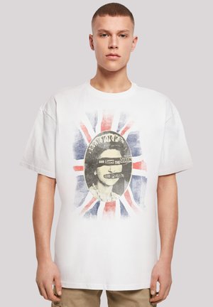 White cotton t-shirt featuring a graphic print of a portrait with "God Save The Queen" text and a Union Jack background in blue and red.
