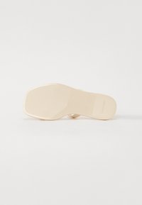 Nude-farvet sandal med en glat, blank overflade, firkantet tådesign og minimalistisk rem. Har logo prægede på sålen.
