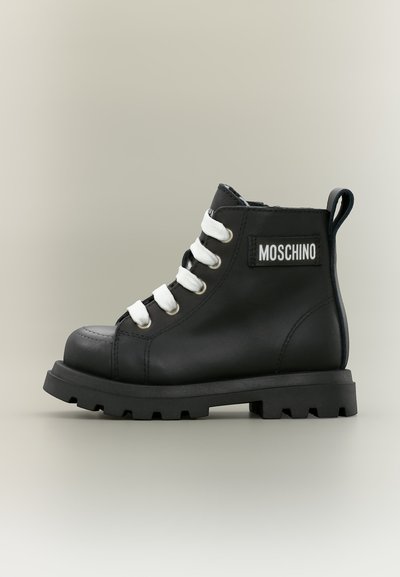 Μαύρο δερμάτινο μποτάκι Moschino με χοντρή σόλα και λευκά κορδόνια, με λαβή και λογότυπο στο πλάι.