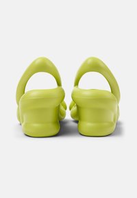 Bright green sandals with a smooth, textured finish, featuring a rounded, cushioned heel and a contoured back design for comfort.
