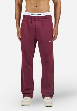 Bordeauxgekleurde sweats met een elastische tailleband en witte PEGA DOR branding. Het ontwerp heeft een relaxte pasvorm en een zachte textuur.