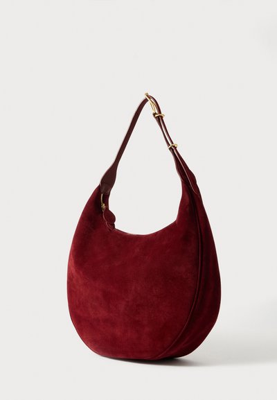 Bordeaux suède hobo tas met een gebogen vorm, verstelbare leren schouderband en gouden hardware-accenten. Gladde textuur, eenvoudig design.