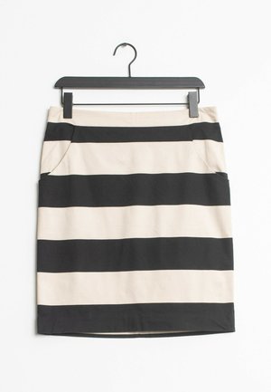 Jupe rayée horizontale noire et beige avec poches latérales suspendue à un cintre noir sur un fond blanc.