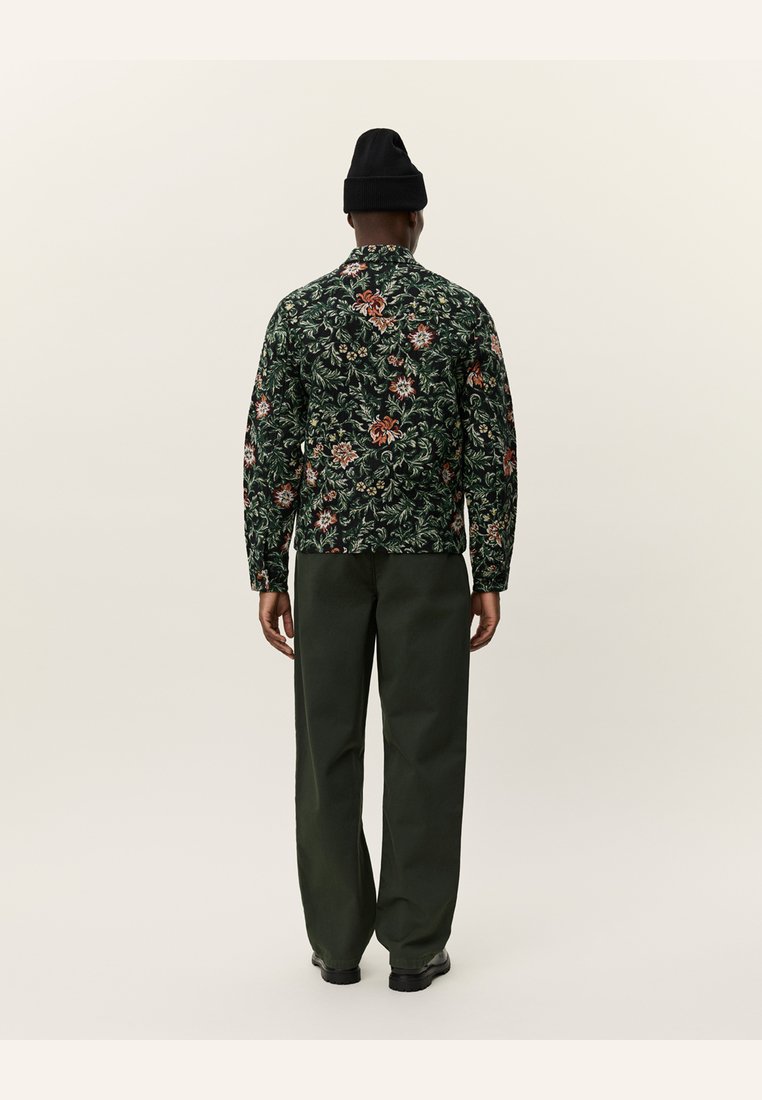 Floral-printed jacket in dark green with red and orange accents, paired with dark green trousers. Features a relaxed fit and long sleeves.