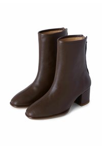 Brown leather ankle boots with a block heel, pointed toe, and side zipper detail. Smooth texture and minimalist design.