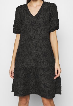 Czarna teksturowana sukienka z krótkimi rękawami typu bufki, dekoltem w kształcie litery V i falbanką opadającą powyżej kolan.