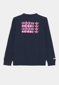 Felpa navy con testo e loghi "adidas" in rosa sul retro. Maniche lunghe con polsini a coste e collo rotondo. Materiale morbido.