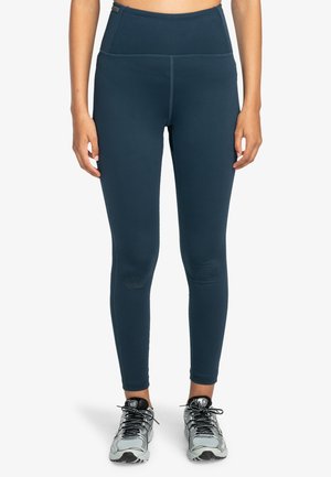Högmidjade, marinblå leggings tillverkade av stretchigt material med en jämn textur. Har platta sömmar och en figurnära design.