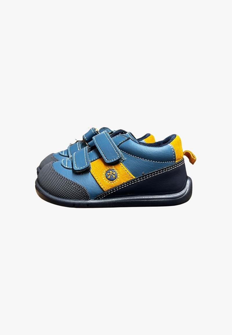 Zapatos para niños pequeños en azul y amarillo con suelas negras, dos correas de velcro y puntas de goma texturizadas, mostrados en vista lateral sobre fondo blanco.