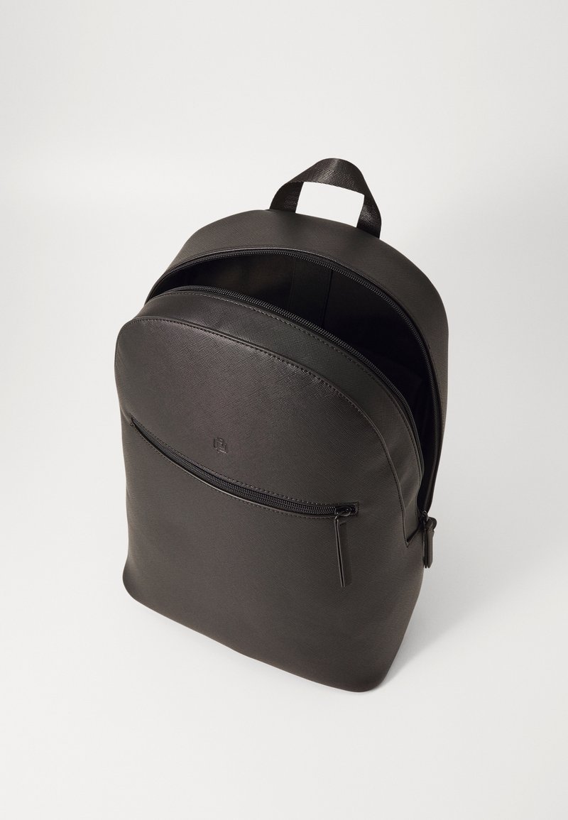 Sac à dos en cuir noir avec une forme arrondie, une poche zippée à l'avant et une poignée supérieure. La texture est lisse et mate.