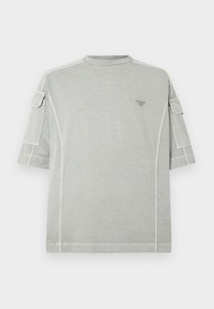 Lysegrå oversize t-shirt med korte ærmer, som har diskrete sidelommer, rund halsudskæring og et lille logo på brystet.