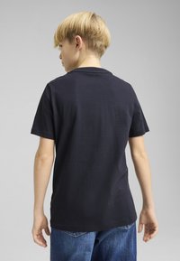 Korte mouwen, marineblauwe T-shirt gemaakt van katoen. Heeft een ronde hals en een rechte snit, met subtiele naden op de achterkant.