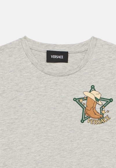 Γκρι βαμβακερό μπλουζάκι με γραφικό από καουμπόικο μπότες και καπέλο μέσα σε πράσινο αστέρι, διακοσμημένο με χρυσά αστέρια και μαύρη ετικέτα «VERSACE».