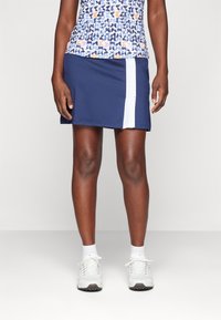 Námořnická sportovní sukně s bílým postranním pruhem; má přiléhavý střih a je vyrobena z texturovaného, elastického materiálu.