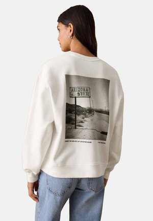 Cremefarbener Sweatshirt mit einer großen Grafik eines "Arizona State"-Schildes auf der Rückseite, mit einem Foto einer Straße und einer Wüstenlandschaft.