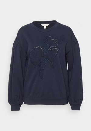 Marineblauwe sweatshirt met een geborduurd bloemenontwerp aan de voorkant, voorzien van textuuraccenten en pofmouwen.