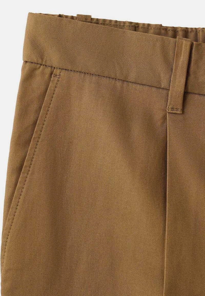 Pantaloni di cotone marrone con finitura strutturata, caratterizzati da una parte anteriore piatta, passanti per cintura e dettagli di cuciture precise.