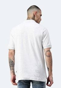 Hellgraues Polohemd mit kurzen Ärmeln und klassischem Kragen, aus einem weichen Stoff gefertigt. Verfügt über umgeschlagene Ärmel und einen lässigen Schnitt.