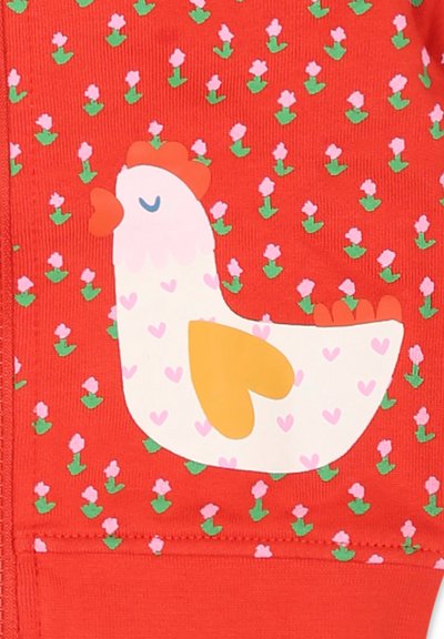 Tessuto rosso con un motivo floreale ripetuto; presenta un grande grafiche di un gallo bianco con un'ala gialla e dettagli a forma di cuore rosa.
