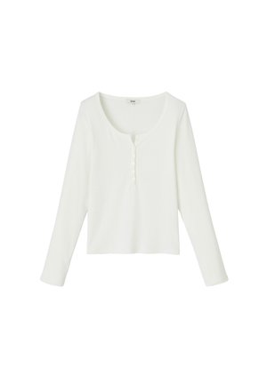 Haut henley à manches longues blanc en tissu doux, avec un col rond, une patte de boutonnage et un ourlet légèrement court.