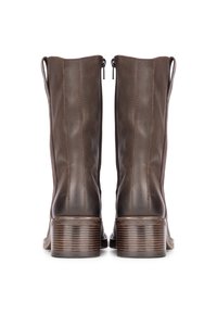 Botas de tobillo de cuero marrón con una textura suave, costuras verticales y un tacón en bloque con rayas horizontales. Detalle de cremallera en la parte posterior.