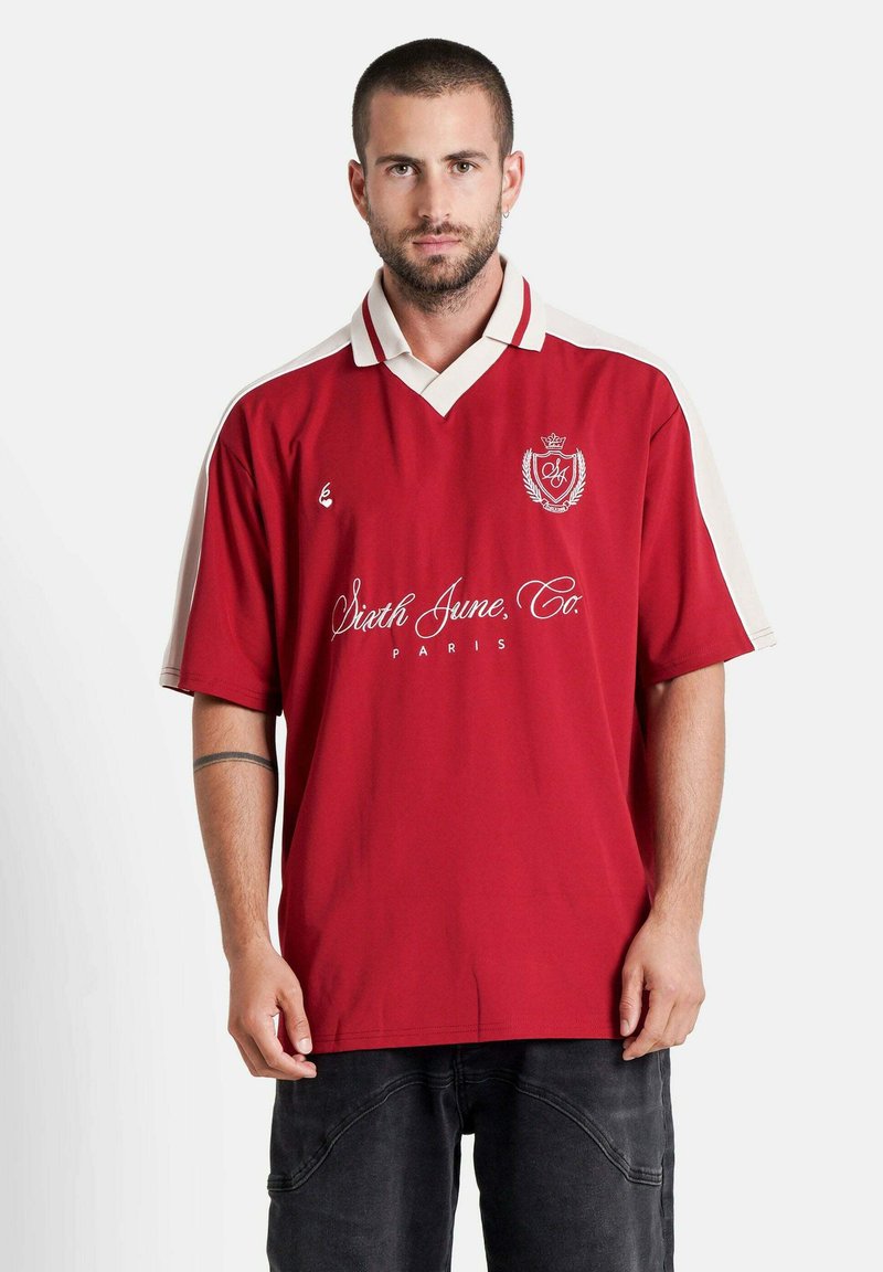 Maillot rouge à manches courtes avec un col blanc et des accents sur les épaules. Affiche un logo central et un motif de texte "Sixth June, Co. Paris".