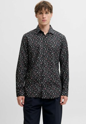 Camicia nera a maniche lunghe con motivo floreale in rosso e bianco, colletto classico, chiusura frontale con bottoni e texture di tessuto morbido.