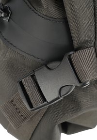 Schwarze Kunststoffschnalle, die einen strukturierten dunkelgrauen Stoffriemen befestigt, detaillierte Nähte sind auf dem Stoff sichtbar, die sowohl die Haltbarkeit als auch das Design verstärken.