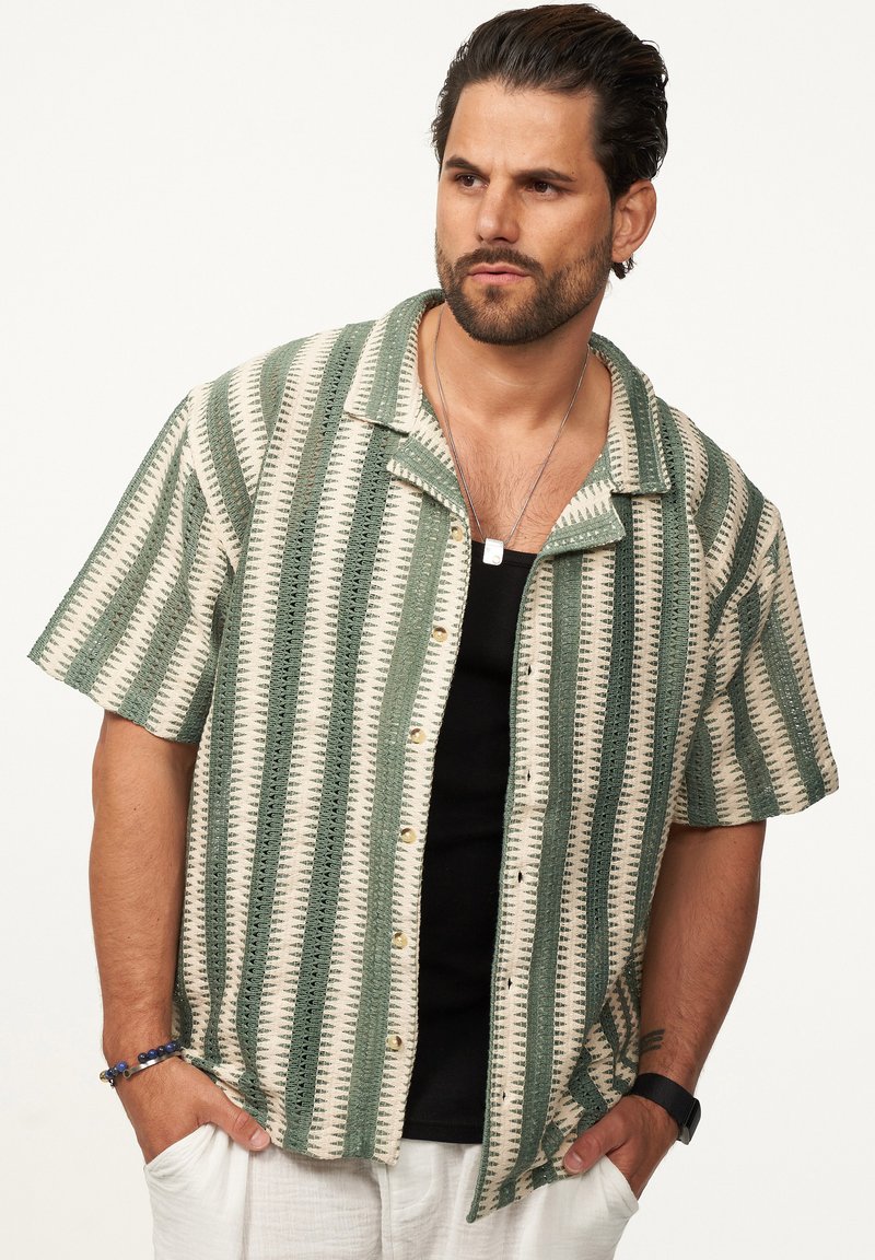 Kurzärmliges Hemd mit Knopfverschluss, das ein creme- und grün gestreiftes Muster aufweist, aus leichtem Stoff mit strukturiertem Finish und einem Kentkragen gefertigt.