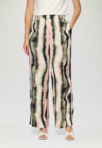 Pantalons larges avec un motif ondulé en rose, vert et noir sur un fond clair, dotés de poches avant et d'une texture lisse.