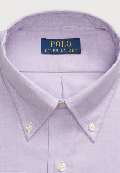 Levanduľová košeľa s button-down golierom, bielymi gombíkmi a jemne textúrovanou tkaninou. Štítok "POLO RALPH LAUREN" v modrej a zlatej farbe.