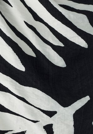 Czarna tkanina z wzorem w paski zebry w białym kolorze. Tekstura wydaje się gładka, z kontrastującymi, wyraźnymi liniami tworzącymi dynamiczny design.