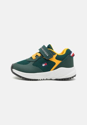 Zielono-żółty dziecięcy sneaker z panelami z siateczki, białą podeszwą, żółtymi sznurowadłami, zapięciem na rzep oraz małym logo Tommy Hilfiger po boku.