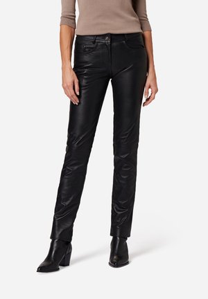 Zwarte leren broek met een slim fit, voorzien van een zachte textuur, subtiele frontzakken en een stijlvolle zoom, gecombineerd met zwarte enkellaarsjes met hoge hakken.