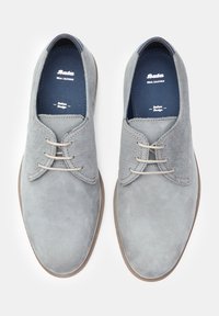 Pantofi din piele gri, cu un finisaj din suede și accente din plasă, vârful rotund și șireturi bej. Textură netedă și culoare neutră.
