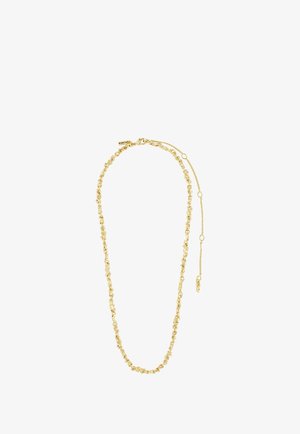 Ung mand med krøllet hår og blå øjne iført en guldkæde og hvid ribbet skjorte mod en ensfarvet baggrund.