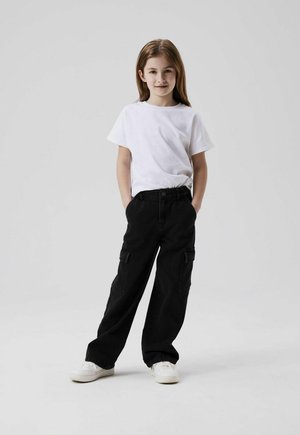 T-shirt blanche à manches courtes, pantalon cargo noir avec poches latérales et baskets blanches. Tenue décontractée avec une coupe ample.