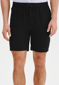 Czarne szorty wykonane z miękkiego materiału, z elastycznym paskiem w talii i sznurkiem do regulacji. Prosty design, do kolan, bez widocznych wzorów.
