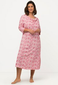 Růžová květinová noční košile s tříčtvrtečními rukávy, skořicovým výstřihem a bočními rozparky. Vyrobena z lehkého materiálu s hladkou texturou.