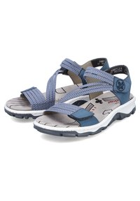 Blaue Sandalen mit Kreuzriemen aus strukturiertem Stoff, braunen Gummisohlen und gepolsterten Fußbetten mit einem dezenten Muster.