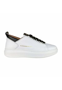 Sneaker bianca con dettagli neri, chiusura con lacci, materiale in pelle liscia e suola rialzata. Presenta un brand dorato sul lato e un design minimalista.