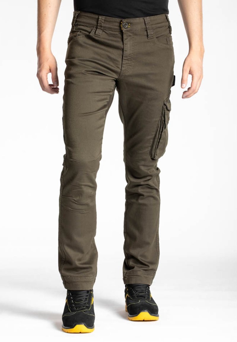 Pantalons cargo vert olive à coupe ajustée, avec poches latérales, coutures visibles et un tissu résistant. Associés à des chaussures noires et jaunes.