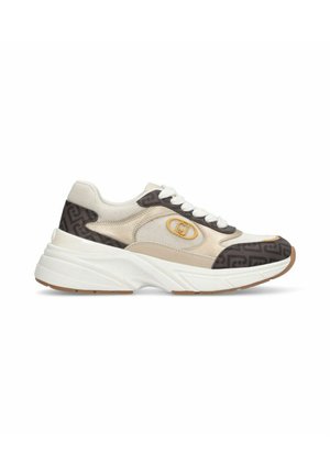 Scarpa da ginnastica beige e marrone con lacci, suola spessa bianca, pannelli in tessuto a rete e fantasia, e dettaglio logo giallo sul lato.