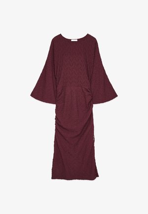 Burgundijas krāsas, teksturēta kleita ar platām piedurknēm, apaļu izgriezumu un savilktām detaļām jostasvietā, līdz potītēm.