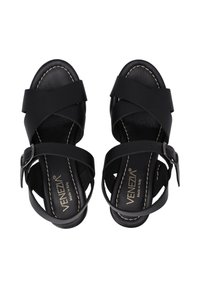 Schwarze Sandalen aus Leder mit überkreuzten Riemen, einer Schnalle und einer weichen Innensohle. Genähte Akzente und eine glatte Oberfläche sind sichtbar.